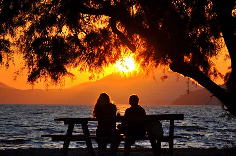 Deux amants assis sur un banc au bord du lac.
